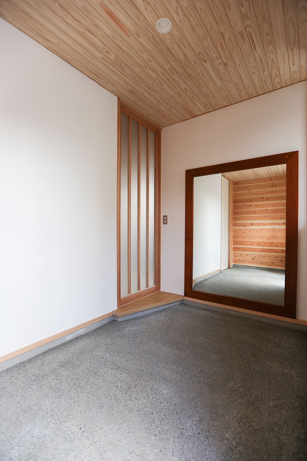 神戸市の木の家 大きな鏡のある洗い出し土間の玄関