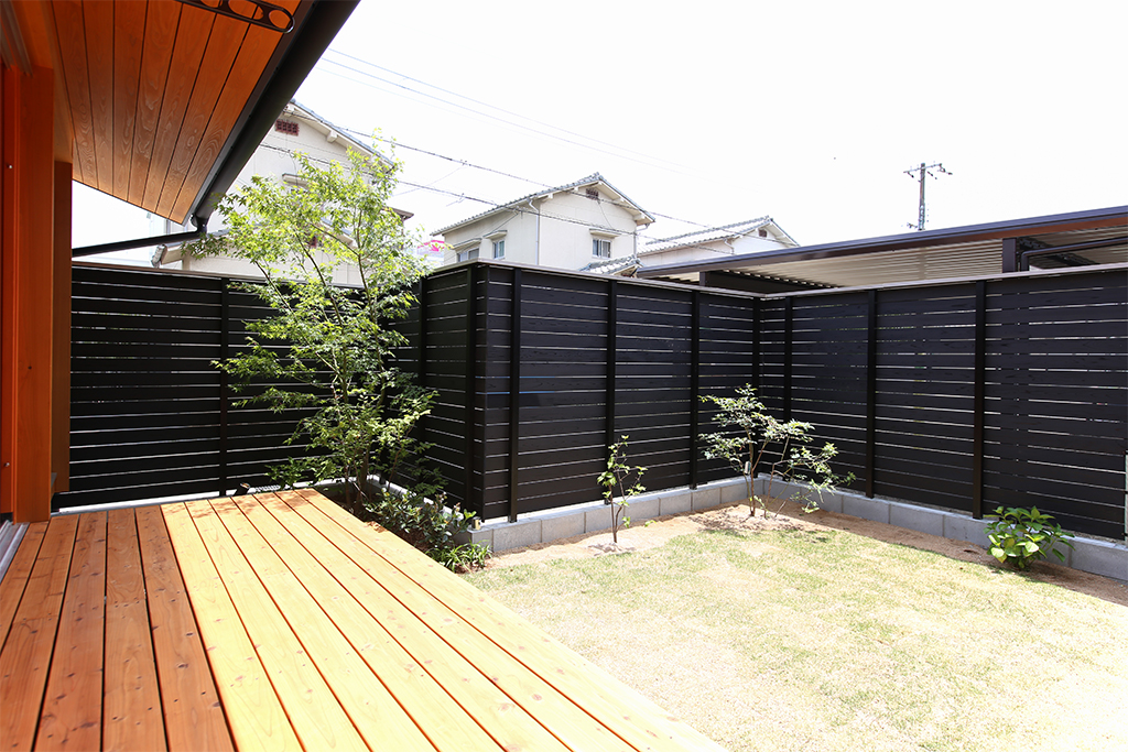 姫路市の木の家 屋根付きのデッキと芝生の庭